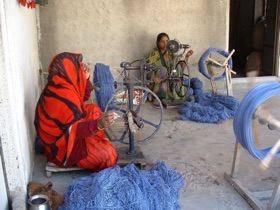 Femmes filant dans un recoin de maison